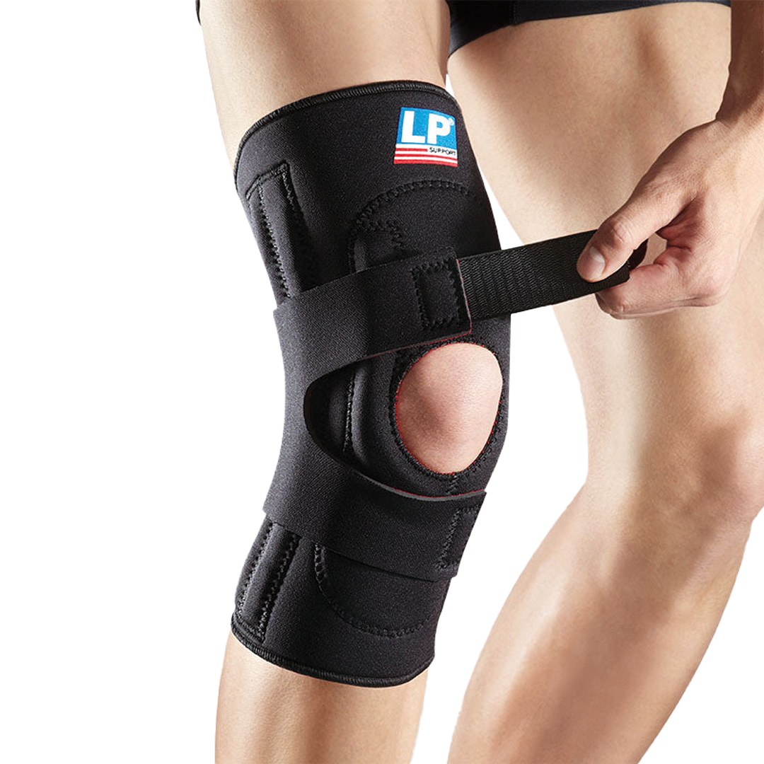 Black knee brace being worn on a person's knee with a visible brand logo.