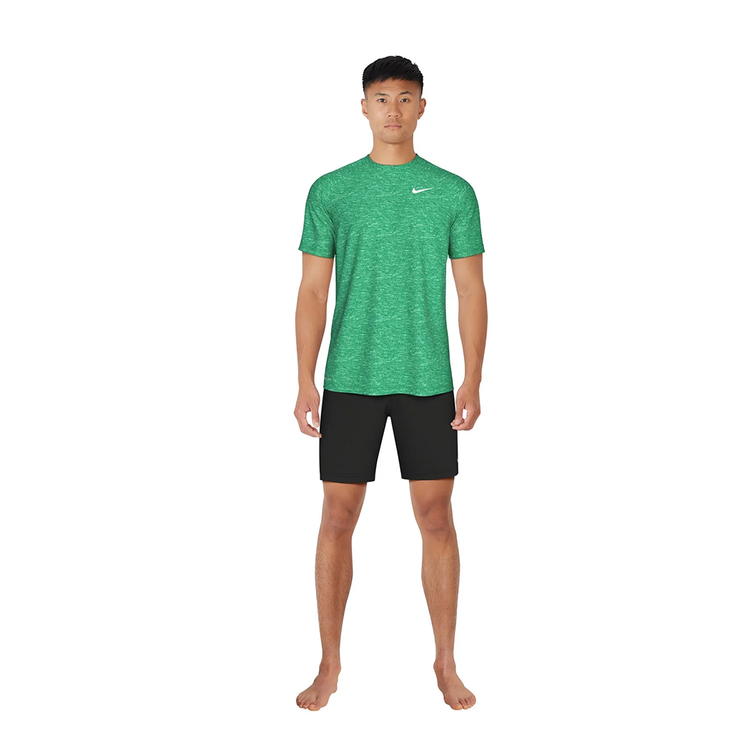 Person wearing a green Nike shirt and black shorts on a white background