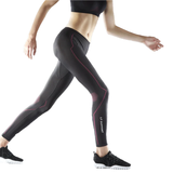 Person wearing black compression leggings with red accents on a white background