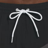 Close-up of black shorts with a white drawstring on a brown background
