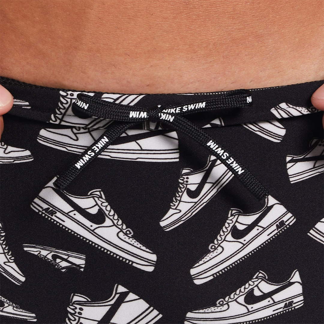 Black swim shorts with white sneaker pattern and Nike branding.