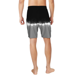 Person wearing a black to gray gradient swim shorts on a white background