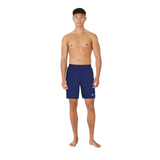Man wearing navy swim shorts with a white logo on a white background