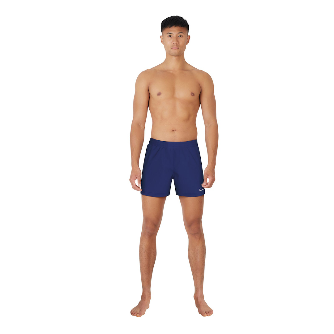 Man wearing navy blue swim shorts with a Nike logo on a white background